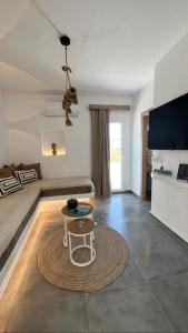 ein Wohnzimmer mit einem Bett und einem Tisch in der Unterkunft Akti Kastraki Beach in Kastraki Naxos