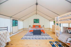 Großes Zimmer mit einem Bett in einem Zelt in der Unterkunft Roaring River Luxury Glamping #3 in Cassville