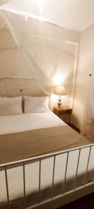 a bedroom with a white bed with a canopy at Persefoni 's hause 1 in Nea Kallikrateia