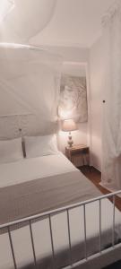 a white bed in a room with a lamp at Persefoni 's hause 1 in Nea Kalikratia