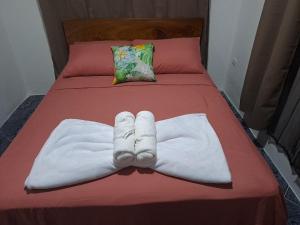 ein Paar Handtücher auf einem Bett in der Unterkunft Casa Chu en Playa Manuel Antonio in Manuel Antonio