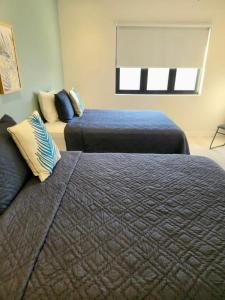 um quarto com 2 camas e uma janela em Villa Blue Moon em Bon Accord