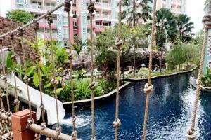 uno scivolo acquatico in un resort con palme di Grande Caribbean Resort a Pattaya Sud