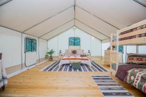 a room with a bed and bunk beds in it at Roaring River Luxury Glamping #4 in Cassville