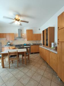 a large kitchen with wooden cabinets and a ceiling fan at Magnolia B&B in Silvi Marina