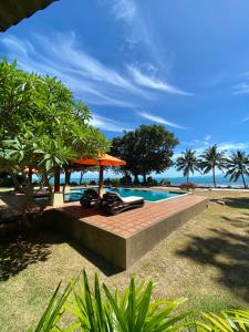 a resort with a swimming pool and an umbrella at Baan Laem Noi Villa's in Mae Nam