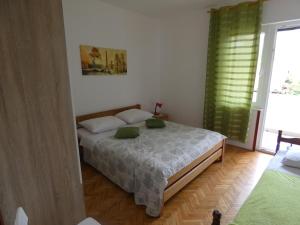 1 dormitorio con cama y ventana grande en Apartman Žarko, en Tkon