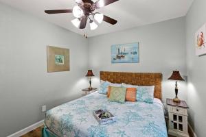 um quarto com uma cama e uma ventoinha de tecto em The Anchor Beach House em Galveston