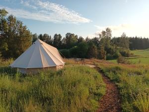 a large tent in a field with a dirt road at Glamping Kiveinen in Laitila