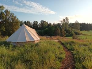 una gran tienda en un campo con un camino de tierra en Glamping Kiveinen, en Laitila