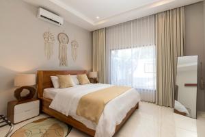 a bedroom with a large bed and a large window at Hills House Villa by Globalstay - Jimbaran x Balangan x GWK in Jimbaran