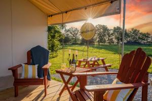 a patio with a table and chairs and an umbrella at Roaring River Luxury Glamping #5 in Cassville