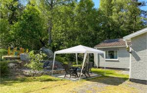 uma mesa e cadeiras debaixo de uma tenda branca num quintal em 3 Bedroom Nice Home In Lammhult em Lammhult