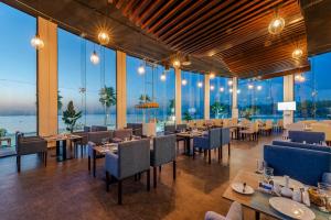 un ristorante con tavoli e sedie e grandi finestre di HDB Al Khobar Resort & Spa a Al Khobar