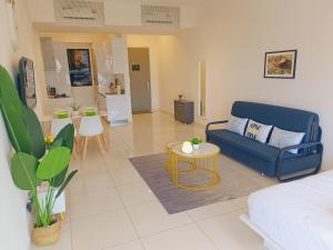 a living room with a blue couch and a table at Rooftop Pool, 8 Pax, 2 Bedrooms, 2 Bathrooms, 2 Car Parks by Star Home in Jelutong