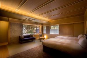 Hotel Yuraku Kyo-yasaka في Giommachi: غرفة فندق بسرير وكرسي ونافذة