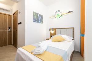 1 dormitorio con 1 cama con sábanas blancas y almohadas amarillas en Hotel Kanjon Zrmanje, en Obrovac