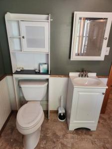 a bathroom with a white toilet and a sink at Fish~N~Moor Cabin in Hammond