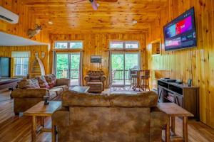 a living room with couches and a flat screen tv at Fish~N~Moor Cabin in Hammond