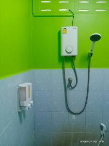 a shower in a bathroom with a green wall at SK Hometel Samui Airport in Bangrak Beach