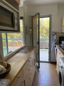 eine Küche mit einer Arbeitsplatte und einer Mikrowelle in der Unterkunft Superbe appartement st mandrier à 100mde la plage in Saint-Mandrier-sur-Mer