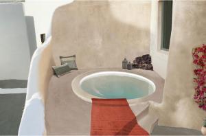 a bathroom with a bath tub with a sink at Ambelia Traditional Villas in Oia
