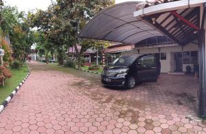 ein unter einer Markierung neben einem Gebäude geparkt in der Unterkunft Villa Edelweis in Pasuruan