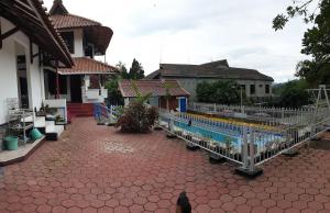 ein Haus mit einem Pool und einem Zaun in der Unterkunft Villa Edelweis in Pasuruan