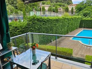 balcón con mesa y piscina en Ladeira, en Baiona