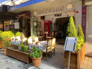 伊斯坦堡的住宿－戈吉斯公寓式酒店，餐厅前面设有桌椅
