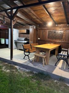 een patio met een houten tafel en een bank bij Casa de vacanta TARA in Eşelniţa