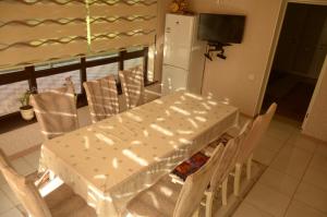 tavolo e sedie bianchi in cucina con frigorifero di Guest House Nazmir 