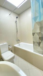 ein Badezimmer mit einer Badewanne, einem WC und einem Waschbecken in der Unterkunft Luxury see view studio Al Marjan in Ras al Khaimah