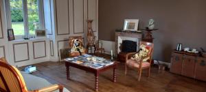 a living room with a table and chairs and a fireplace at Chambres d'hôtes La Babinerie in Saint-Léonard-de-Noblat