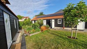 una casa con un patio con un banco y un árbol en Bed en Brood Donna en Pijnacker