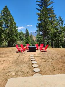 a group of red chairs and a table in a park at Moonrise Lodge - A Large Vacation Home in Mariposa in Mariposa