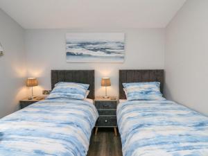two beds sitting next to each other in a bedroom at Cornerstones Brython in Tenby