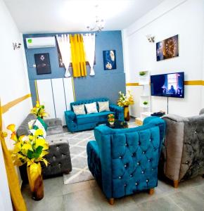 salon z niebieskimi krzesłami i kanapą w obiekcie Appartement meublé w mieście Duala