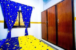 a bedroom with a bed with a blue curtain with stars at Appartement meublé in Douala