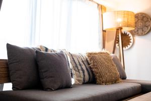 un sofá con almohadas en la sala de estar en Tomariehotel & condominium en Fukuoka