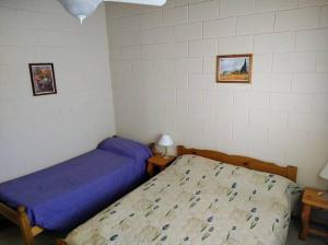 1 Schlafzimmer mit 2 Betten und 2 Bildern an der Wand in der Unterkunft Tamya-Waira in Charbonier
