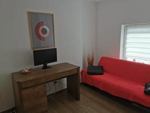 a living room with a red couch and a table at Harmony Haven - Spacious 4BR House with Free Parking in Cluj-Napoca +18 photos