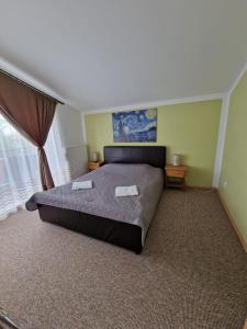 a bedroom with a large bed and a window at Harmony Haven - Spacious 4BR House with Free Parking in Cluj-Napoca