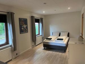 a bedroom with a bed and two windows at SleepOver in Rødby! Few minutes from Femern Tunnel and Ferry to Puttgarden in Rødby