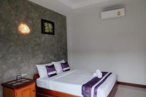 1 dormitorio con 2 camas con almohadas moradas y blancas en พูลสวัสดิ์ รีสอร์ท อ่าวมะนาว, en Changwat Prachuap Khiri Khan