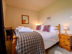 sypialnia z dużym łóżkiem i komodą w obiekcie Shepherds Cottage w mieście Ambleside