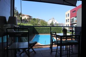 a balcony with a table and chairs and a swimming pool at Ladeira in Baiona