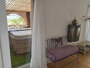 a room with a bed and a tv and a window at Le Spa panoramique du plateau in Valensole