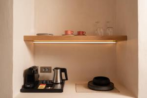 a room with a shelf with a coffee maker on it at Acanthus Oia - Suites With Private Hot Tub in Oia