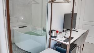 a bathroom with a tub and a table and a sink at Kalista in Cagliari